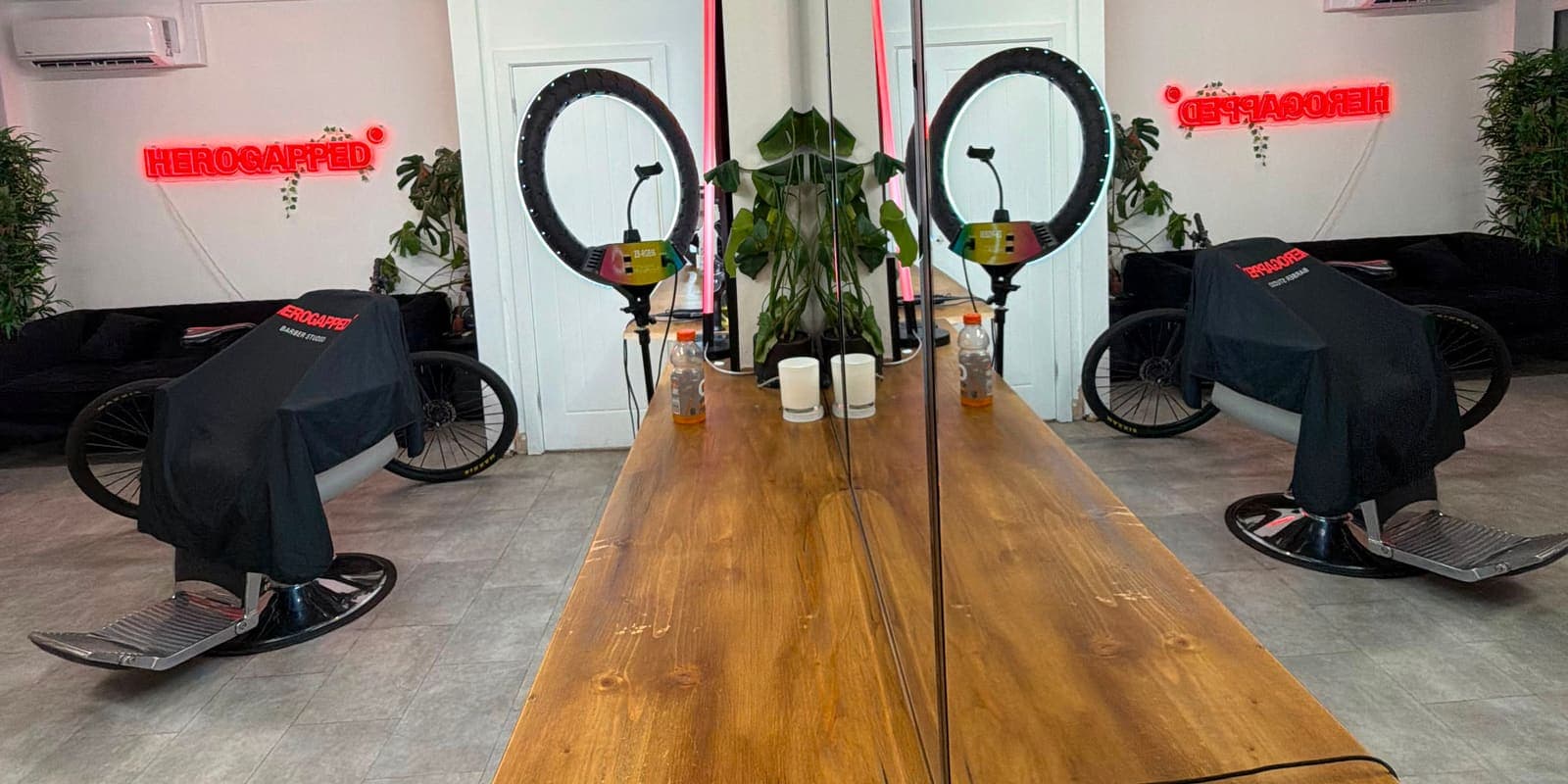Double-sided mirror bench with HeroGapped-caped barber chairs either side