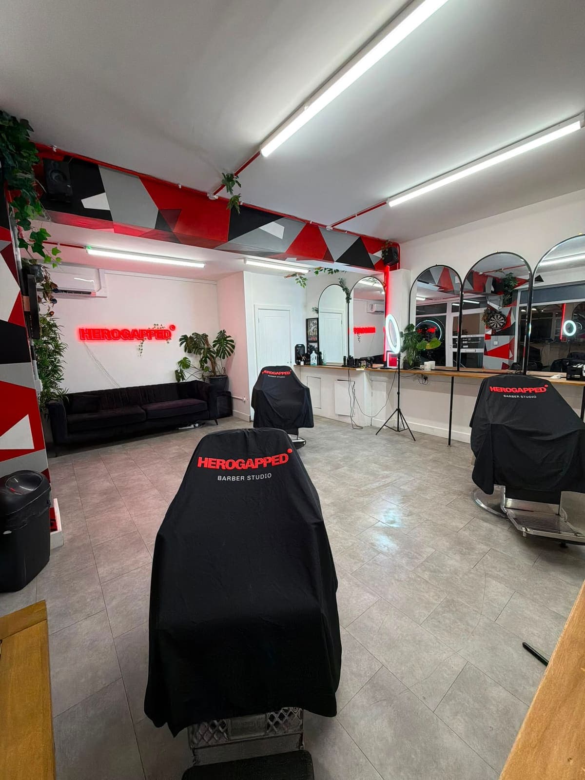 Shopfloor with HeroGapped-caped chairs, arched mirrors and the neon sign