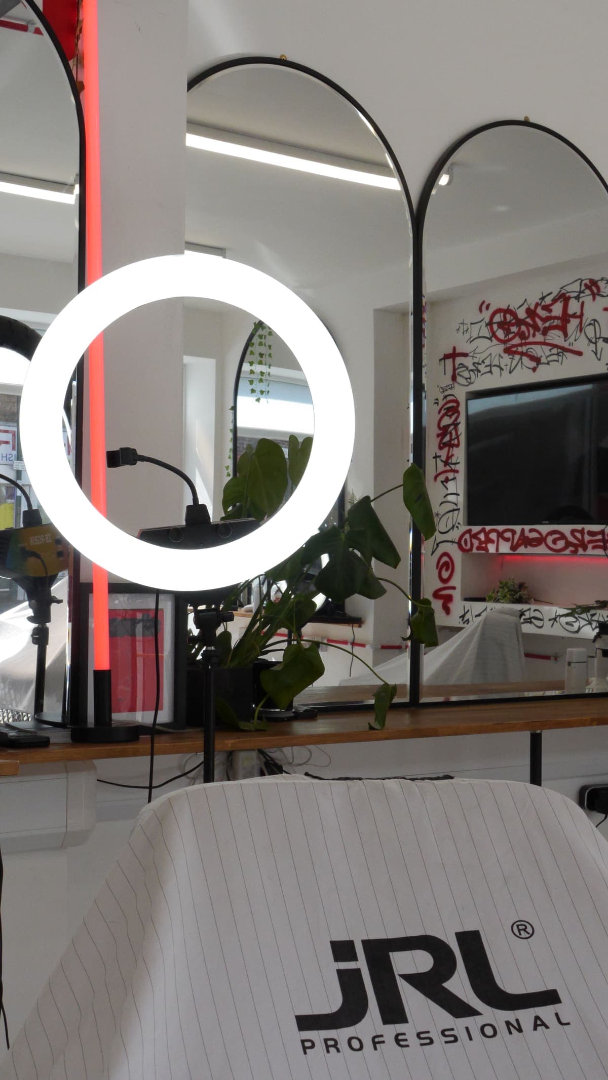 Ring light and arched mirrors above the wooden counter