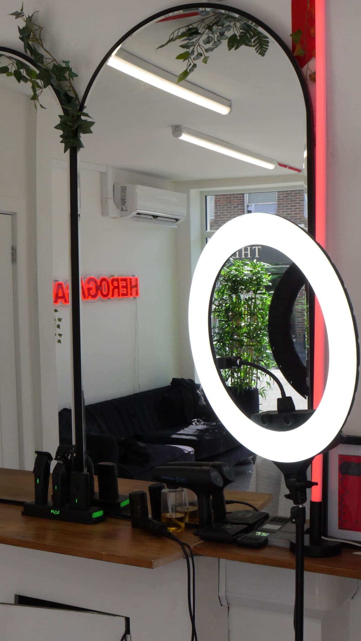 Ring light in front of an arched mirror reflecting the HeroGapped neon
